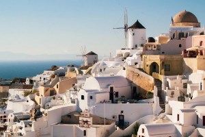Λευκά σπίτια και ανεμόμυλοι σε νησί των Κυκλάδων πάνω από τη θάλασσα