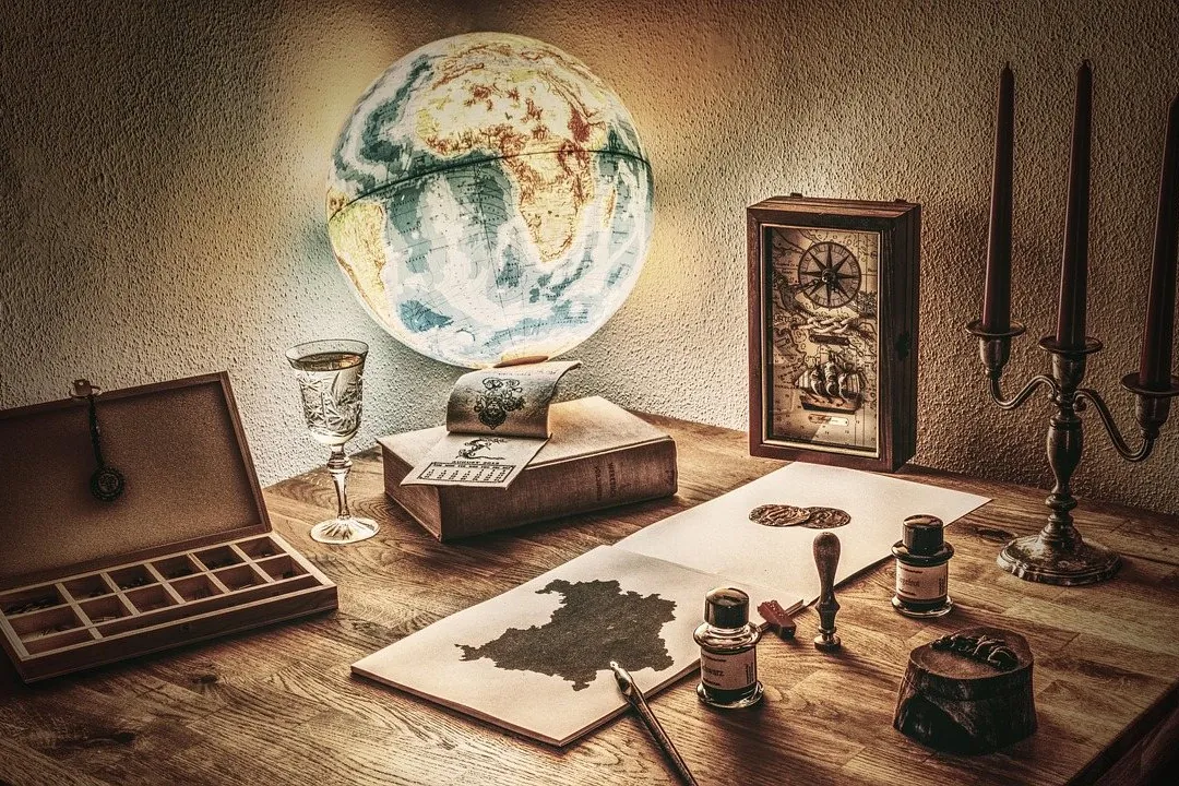 A globe, a map and inkwells on an old wooden desk