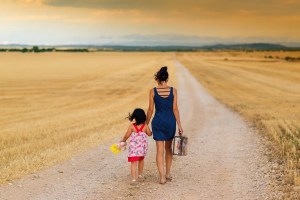 Μητέρα και κόρη περπατούν σε χωματόδρομο ανάμεσα σε χωράφια