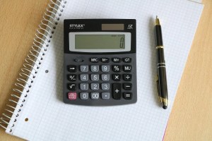 Αριθμομηχανή και στυλό πάνω σε τετράδιο