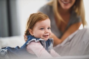 Μικρό κορίτσι χαμογελά δίπλα στη μητέρα του