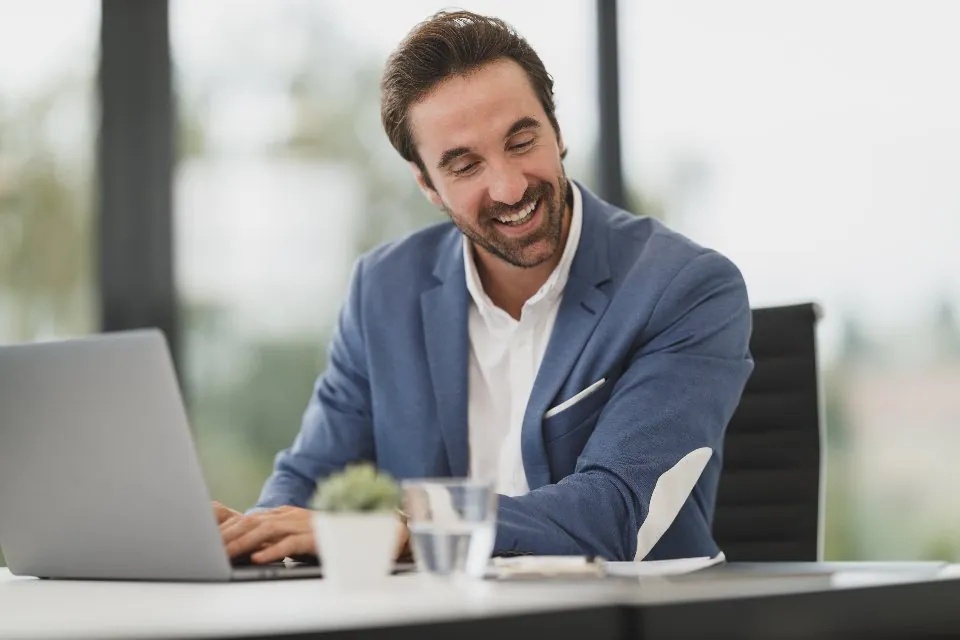 A smiling professional at his laptop