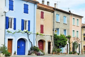 Χρωματιστά σπίτια με παντζούρια σε δρόμο χωριού